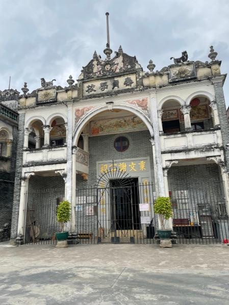 Restored historic hall with an ornate gable and arched entrance in Cangdong Village, Kaiping