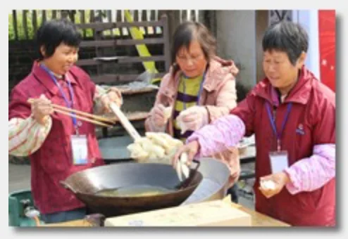 Village women cooking a traditional dish in a large wok